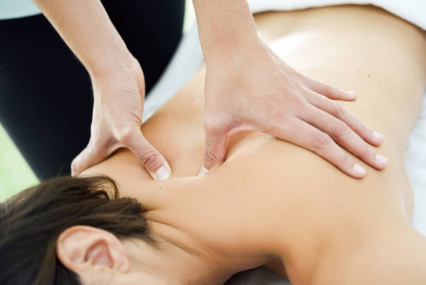 Young woman receiving a back massage in a spa center. - Fotó, kép