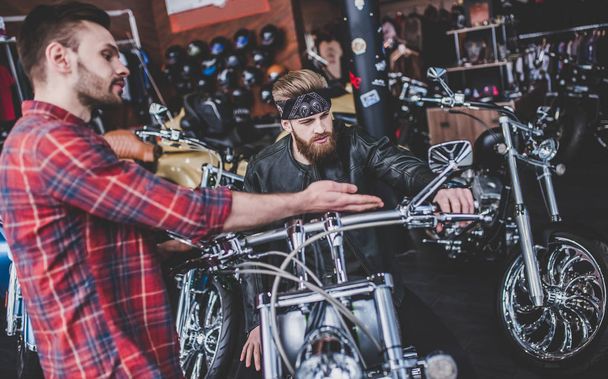 Мужчины в магазине мотоциклов
 - Фото, изображение