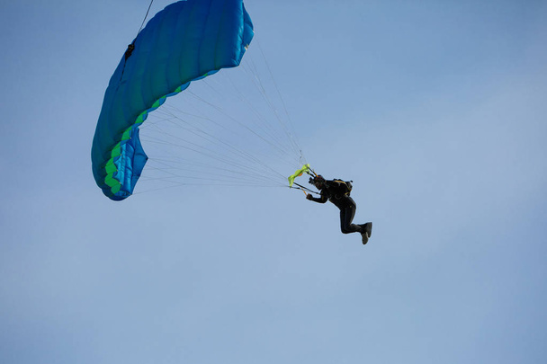 Paraquedistas com Paraquedas Azuis contra Céu Azul Claro
 - Foto, Imagem