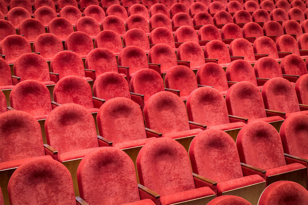Pohled z schody v řádcích pohodlné červené židle v divadle nebo kině. Křivka červených křesel - Fotografie, Obrázek