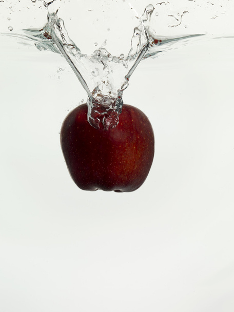 apple dropping on clear water - Foto, afbeelding