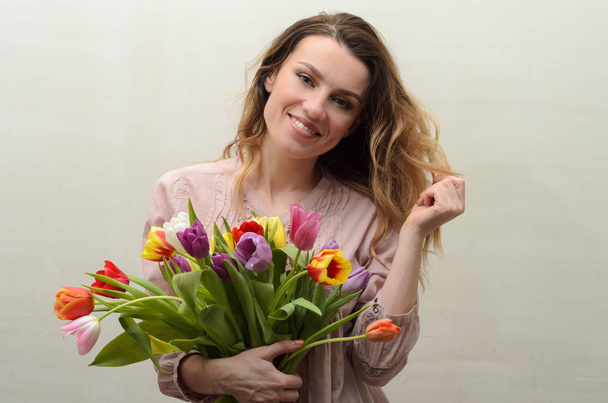 Young charming girl with a bouquet of flowers - multi-colored tulips - Foto, Imagem