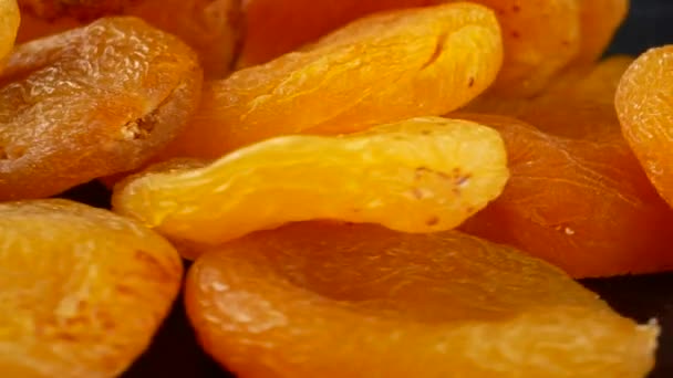 Naturally dried apricots on black background - Materiał filmowy, wideo