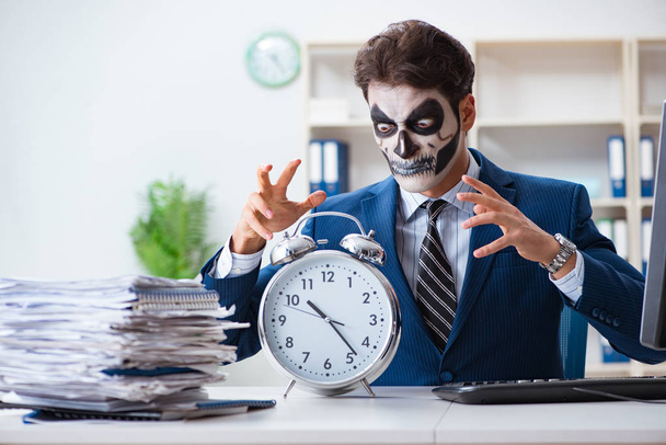 Businessmsn avec effrayant masque facial de travail dans le bureau - Photo, image