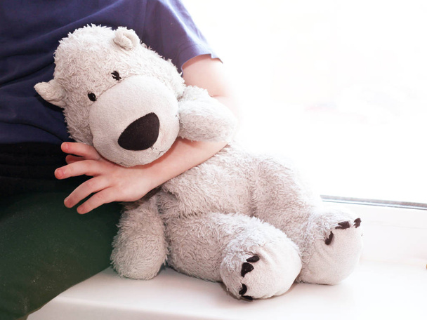 Portret van kleine jongen met teddy beer thuis - Foto, afbeelding