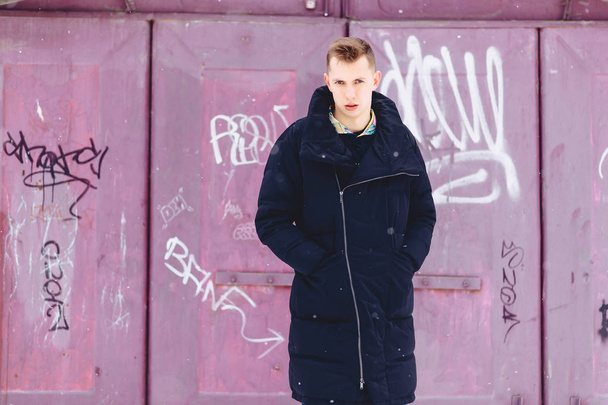 boy in a winter jacket against the background of the wall - Fotoğraf, Görsel