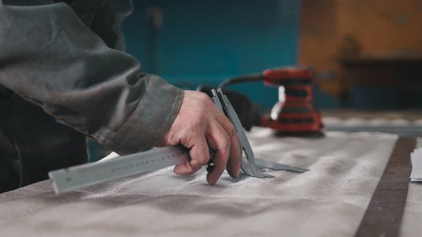 Trabalhador fazendo medições e marcas na peça de metal usando um paquímetro
 - Foto, Imagem