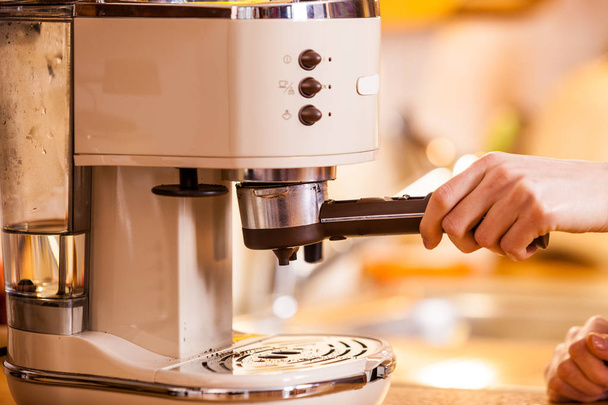 Woman in kitchen making coffee from machine - Valokuva, kuva