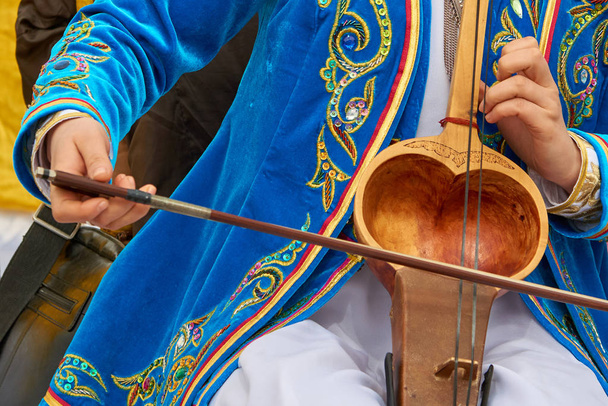 Παίζει ένα μουσικό όργανο kobyz. Η kobyz ή ql-kobz είναι ένα αρχαίο μουσικό όργανο του Καζακστάν συμβολοσειρά. Έχει δύο σειρές από χοντρότριχες. Αντηχούν κοιλότητα καλύπτεται συνήθως με κατσικίσιο δέρμα.  - Φωτογραφία, εικόνα