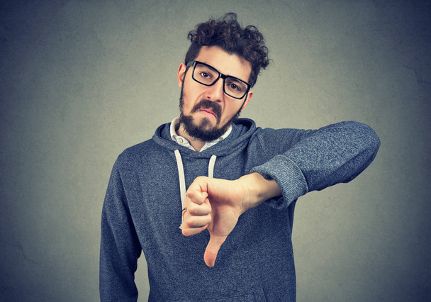 Человек в очках показывает неприязнь с опущенным пальцем
 - Фото, изображение