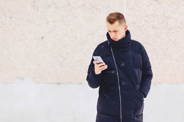 guy in winter jacket writes sms - Photo, Image