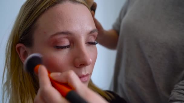 Make-up artist stosuje się proszek i sprawia, że korekta kształtu twarzy do dziewczyny - Materiał filmowy, wideo