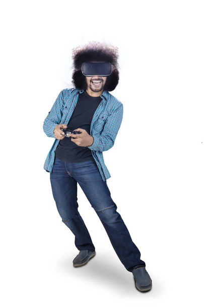 Young man with afro hair addicted playing a virtual reality video game isolated over white. - Photo, image