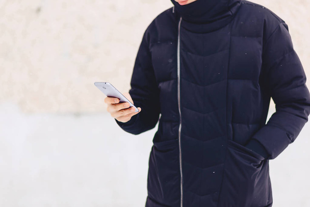 guy in winter jacket writes sms - 写真・画像