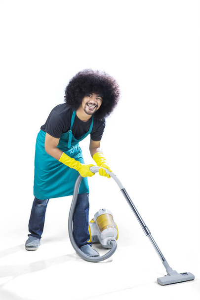 Joven servicio de limpieza profesional utilizando aspiradora
 - Foto, imagen
