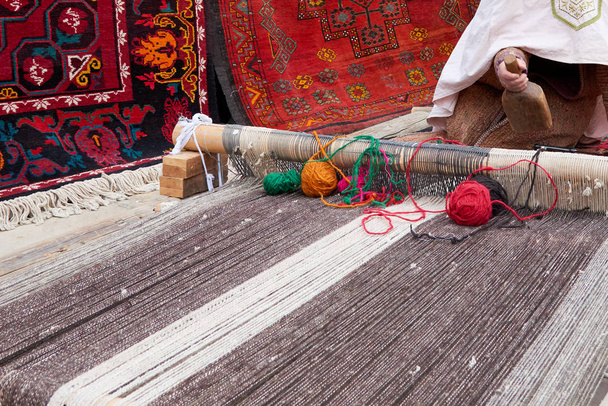 Teppichweberei. Ein Teppich ist ein textiler Bodenbelag, der typischerweise aus einer oberen Schicht Flor besteht, die an einer Unterlage befestigt ist.. - Foto, Bild