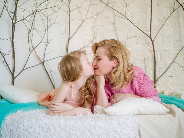 Kiss of Mom and Daughter. Mothers love. A happy family - Photo, Image