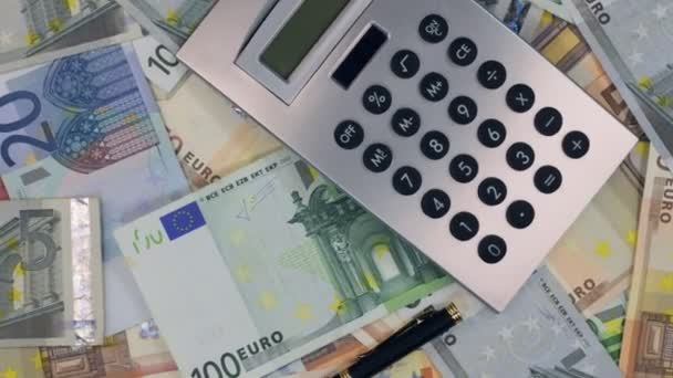 Rotation of the calculator and pen lying on the euros. - Кадри, відео