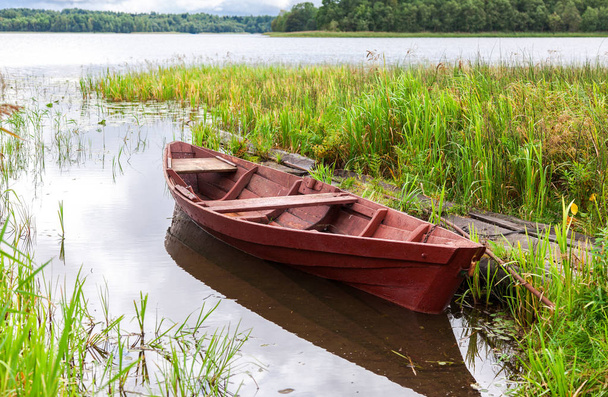 Antiguo barco de pesca de madera en el lago en el soleado día de verano
 - Foto, Imagen