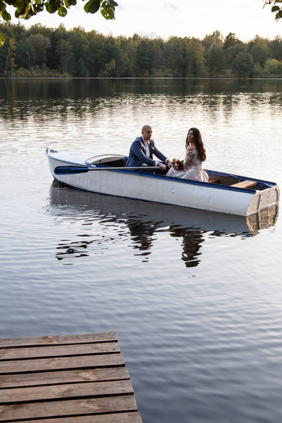 beautiful young couple boating on the lake at sunset. two people. woman and man - Fotografie, Obrázek
