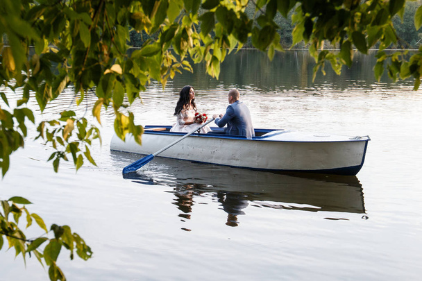 loving wedding couple in a boat on the lake - Φωτογραφία, εικόνα