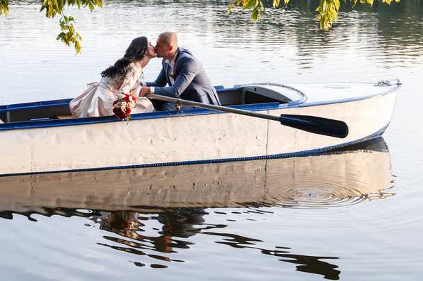 loving wedding couple in a boat on the lake - Zdjęcie, obraz