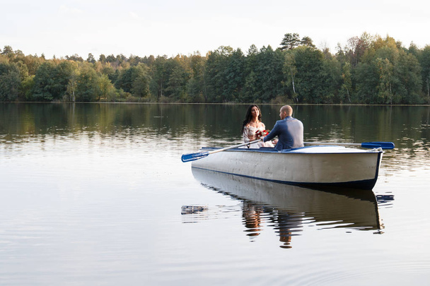 loving wedding couple in a boat on the lake - Fotografie, Obrázek