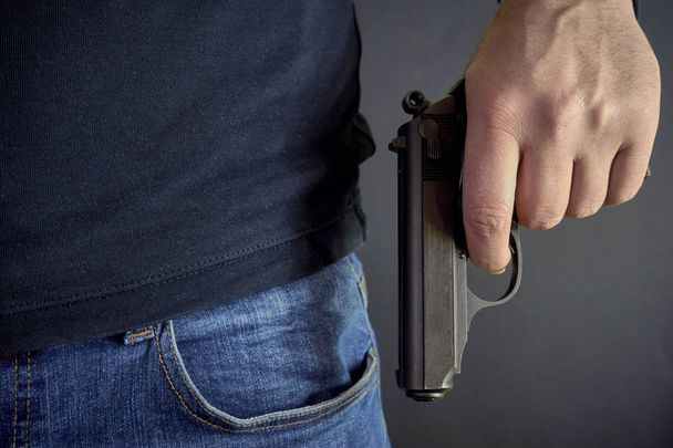 Killer holding a gun side him, robbery, murder, crime - Photo, Image