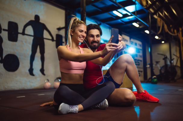 Νεαρό ζευγάρι λαμβάνοντας μια selfie στο γυμναστήριο. - Φωτογραφία, εικόνα