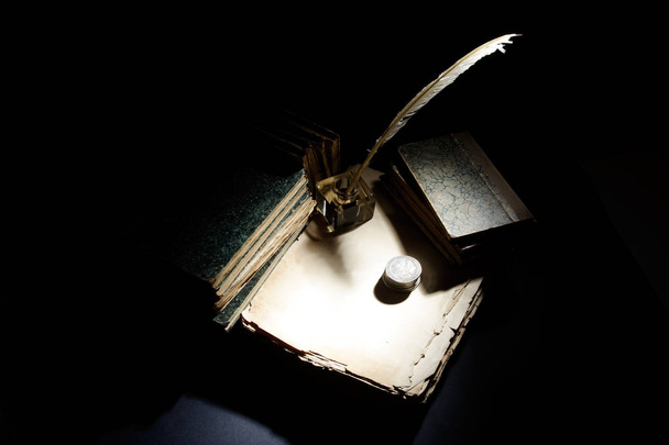 Old fountain pen, papers and inkwell and silver coins on a black background - Fotografie, Obrázek