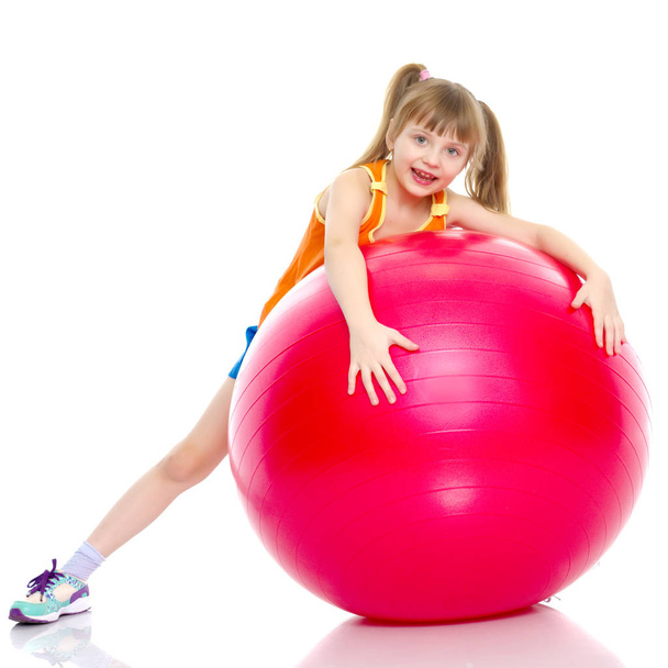 little girl doing exercises on a big ball for fitness. - Foto, imagen