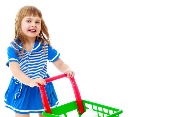 Little girl with a cart in the supermarket. - Foto, afbeelding