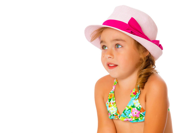 A small tanned girl in a swimsuit and a hat. - Foto, Imagem