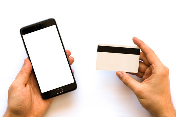 pitämällä käsi luottokortti ja käyttämällä älypuhelinta Musta älypuhelin mallina ja luottokortti käsissä Lähikuva kuva liikemies. Online-maksut muovikortti. Horisontaalinen mallinnus. Hämärtyminen, kalvon vaikutus
 - Valokuva, kuva