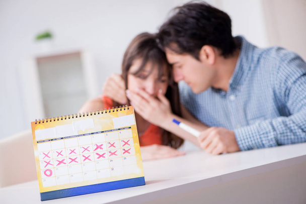 Молодая семья в концепции планирования беременности с календарем овуляции - Фото, изображение