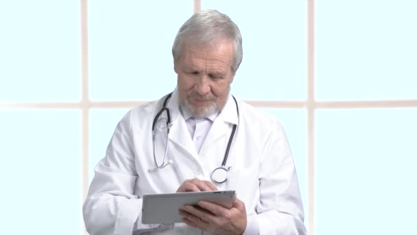 Older doctor working on computer tablet. - Footage, Video