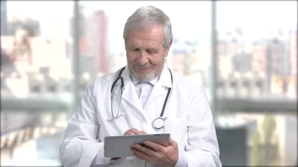 Senior médico sonriente con la tableta de PC
. - Imágenes, Vídeo