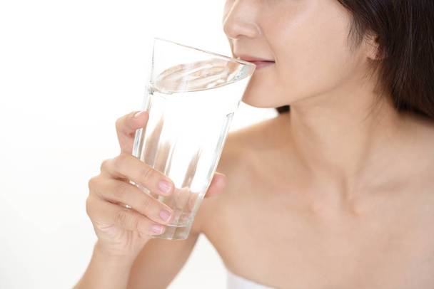 Vrouw die een glas water drinkt - Foto, afbeelding