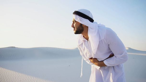 Joven emirato masculino sufre de dolores severos en el abdomen, standin
 - Foto, imagen