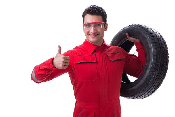 Joven reparador de neumáticos con monos rojos aislados sobre fondo blanco
 - Foto, imagen