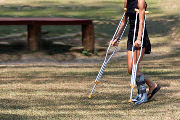 Accidente de turista chica están caminando por muletas en el jardín
. - Foto, Imagen