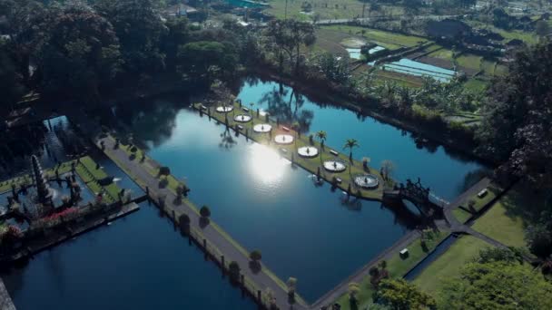 Filmato aereo di bellissimo giardino sull'acqua con un lago, architettura, fontane, ponti, viali, gazebo. Bali Indonesia. Riprese video 4K dal drone aereo mavic pro dall'alto
. - Filmati, video
