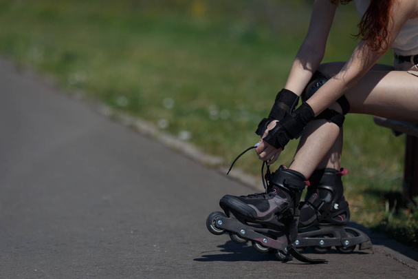 Jong meisje is het dragen van outfits voor rolschaatsen op warme zonnige dag. - Foto, afbeelding