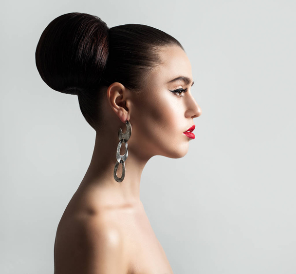 Elegant Fashion Model with Hair Bun Hairstyle on Background - Photo, Image