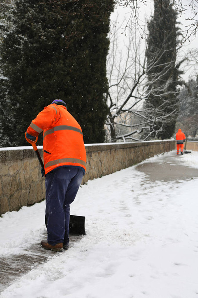 歩道の掃除人として彼は雪をシャベル - 写真・画像