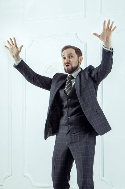Bearded excited businessman is standing in the office with the rised hands. - Photo, Image