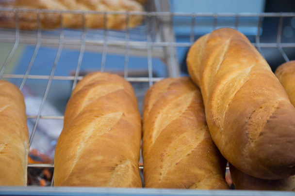 freshly baked bread and baked goods on the shelves on the counter of the bakery - Foto, Imagem