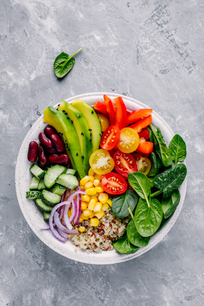 Almuerzo vegano saludable Buda bowl. Ensalada de verduras de aguacate, quinua, tomate, pepino, judías rojas, espinacas, cebolla roja y pimentón rojo
.  - Foto, Imagen