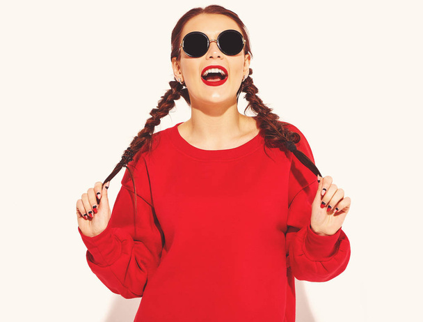 Portrait of young happy smiling woman model with bright makeup and colorful lips with two horns and sunglasses in summer red clothes isolated on white. Going crazy - Photo, image