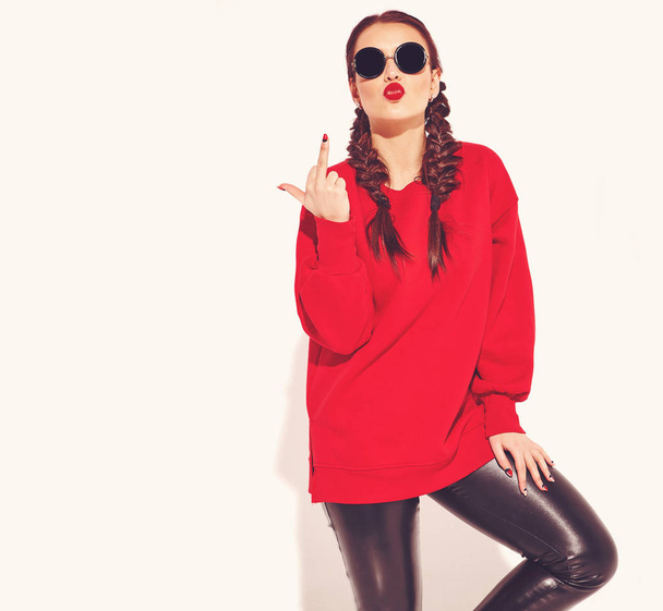 Portrait of young happy smiling woman model with bright makeup and colorful lips with two horns and sunglasses in summer red clothes isolated on white. Going crazy and showing fuck off sign - Foto, Imagem